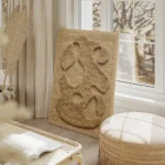 affiche abstraite beige avec des formes organiques texturees sur un fond tricote salon beige.webp