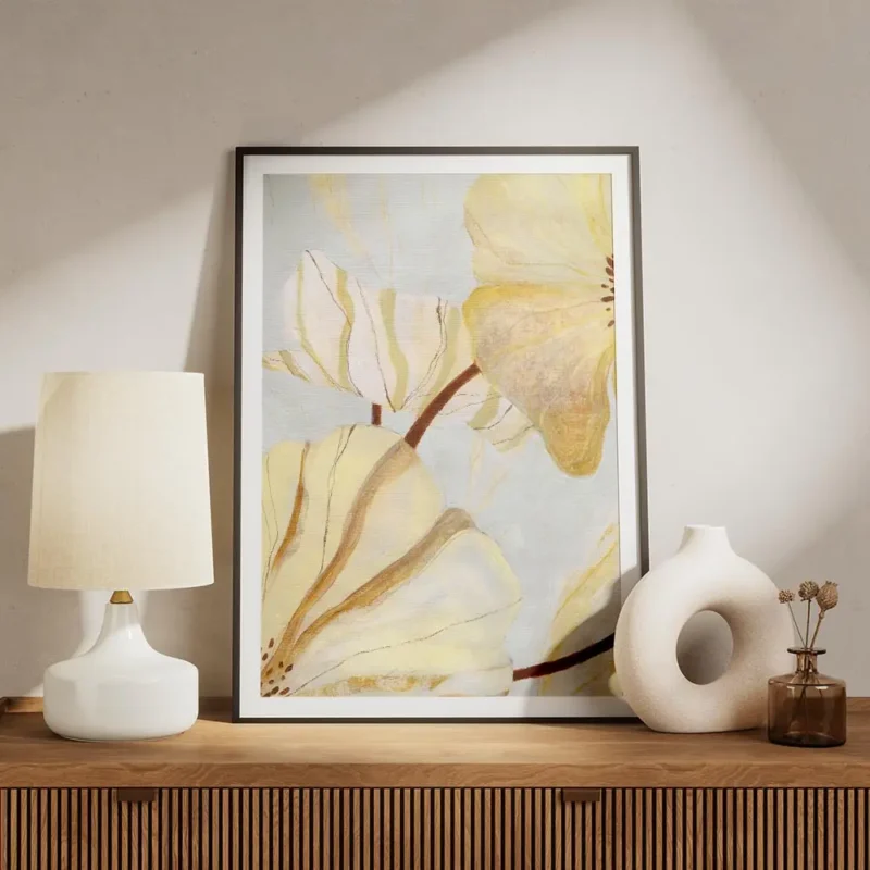 affiche abstraite de fleurs jaunes et blanches aux contours dores et marron sur meuble.webp