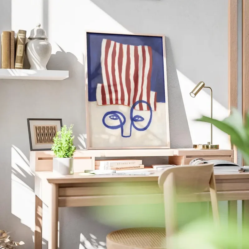 affiche abstraite dun visage bleu minimaliste avec un chapeau a rayures rouges e bureau.webp