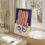 affiche abstraite dun visage bleu minimaliste avec un chapeau a rayures rouges e salon beige.webp