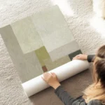 affiche abstraite aux tons neutres beige gris et vert olive avec un carre rouill au sol.webp