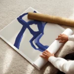 affiche abstraite avec des formes bleues sur un fond beige typographie noire en enroule.webp