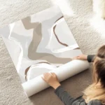 affiche abstraite beige et bleue presentant des formes organiques et des lignes au sol.webp