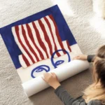 affiche abstraite dun visage bleu minimaliste avec un chapeau a rayures rouges e au sol.webp