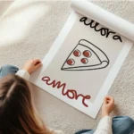 affiche allora amore une illustration de part de pizza avec du texte noir et rou en rouleau.webp