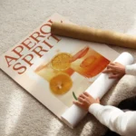 affiche aperol spritz authentique avec deux verres a cocktail texte orange vif e enroule.webp