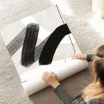 affiche avec coups de pinceau abstraits noirs et blancs et ligne noire sur fond au sol.webp