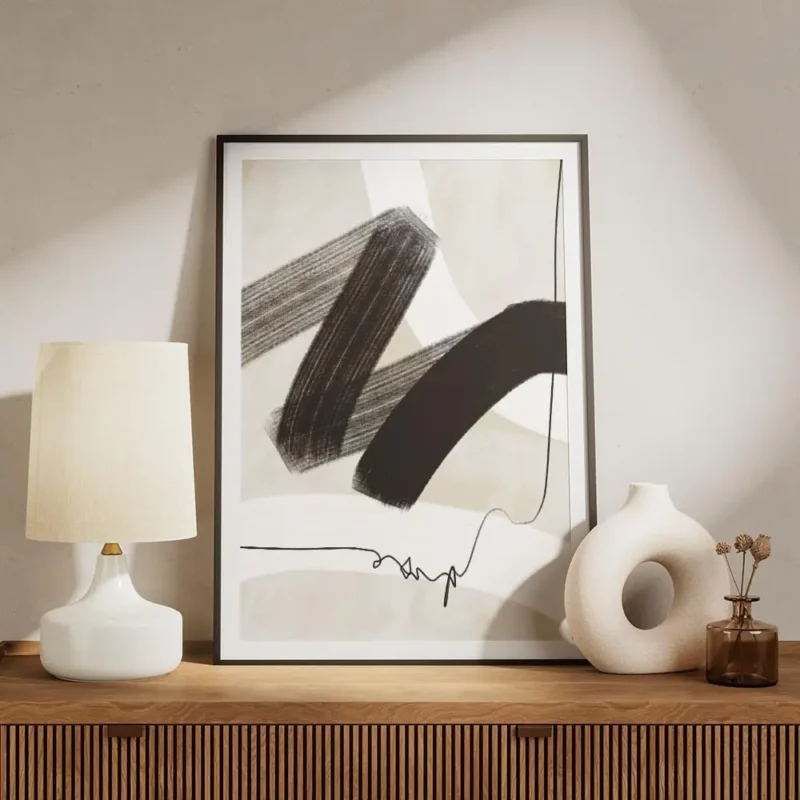 affiche avec coups de pinceau abstraits noirs et blancs et ligne noire sur fond meuble.webp