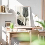 affiche avec de grandes feuilles de bananier vert fonce et blanc casse sur un fo bureau.webp