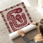 affiche avec des corps abstraits rouge beige fonce et vert presentant des yeux e au sol.webp