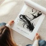 affiche avec des eclaboussures de peinture noire abstraite sur un fond beige et en rouleau.webp