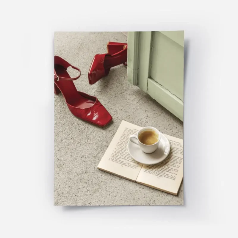affiche avec des escarpins rouges brillants un livre ouvert et une tasse de cafe.webp