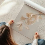 affiche avec des feuilles beiges et roses en cascade sur une branche sur un fond en rouleau.webp