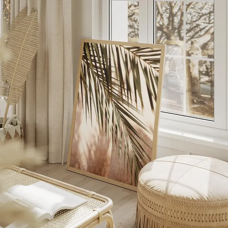 affiche avec des feuilles de palmier vertes projetant des ombres sur un mur rose salon beige.webp