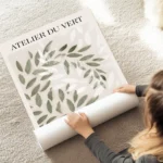 affiche avec des feuilles vertes et blanches superposees sur un fond beige avec au sol.webp