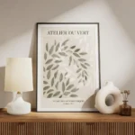affiche avec des feuilles vertes et blanches superposees sur un fond beige avec meuble.webp