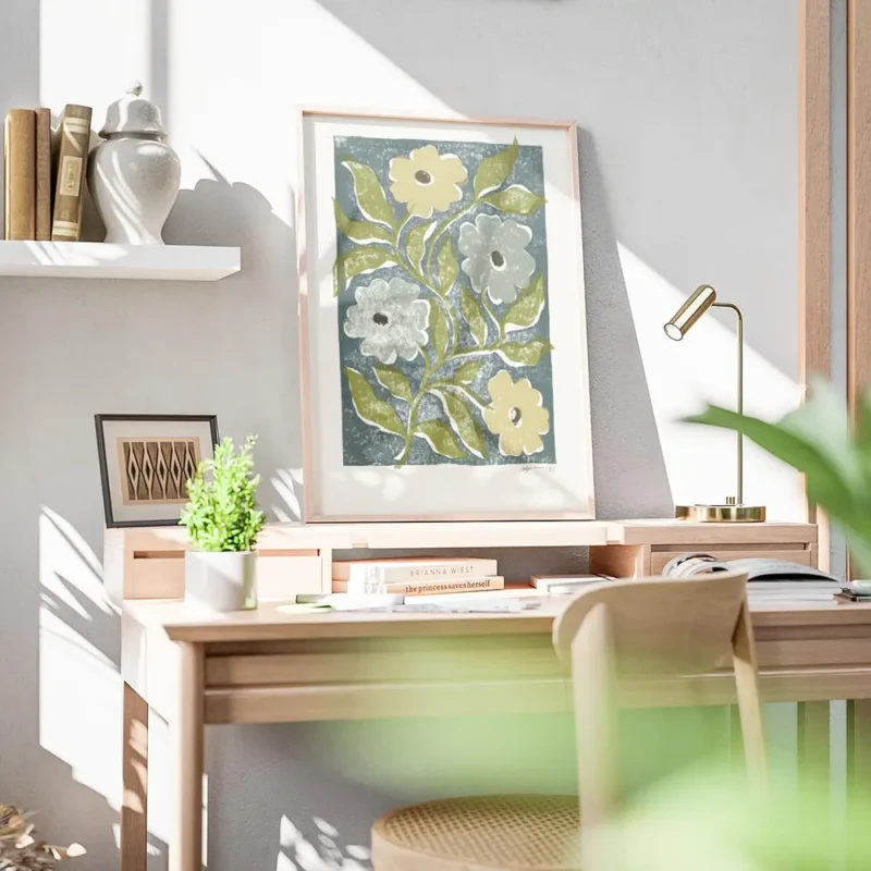 affiche avec des fleurs stylisees jaunes et bleues et des feuilles vertes sur un bureau.webp