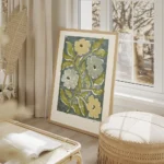 affiche avec des fleurs stylisees jaunes et bleues et des feuilles vertes sur un salon beige.webp