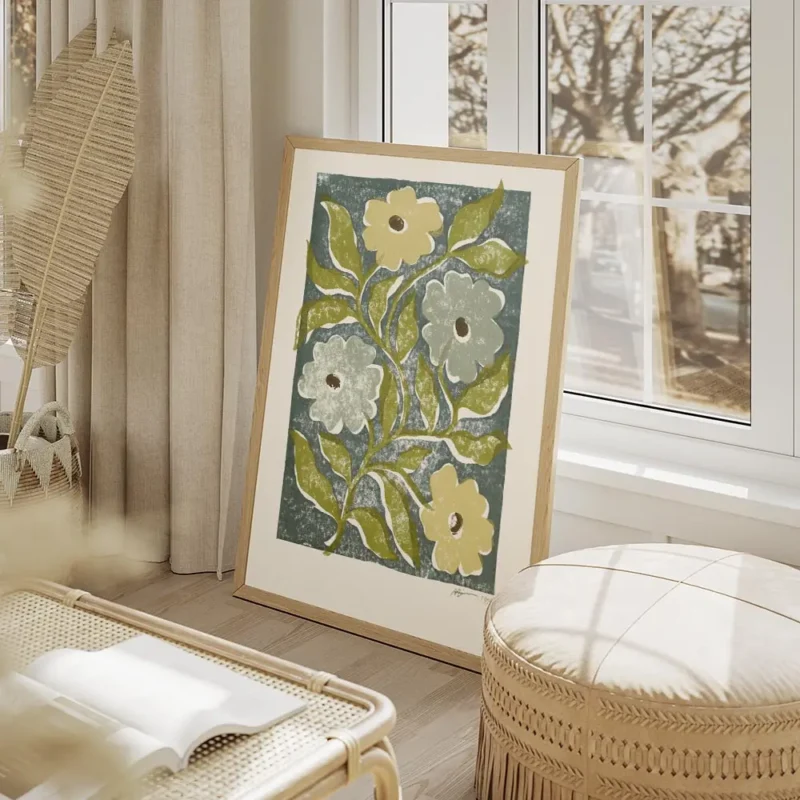 affiche avec des fleurs stylisees jaunes et bleues et des feuilles vertes sur un salon beige.webp