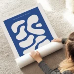 affiche avec des formes abstraites beige sur fond bleu fonce avec du texte en ty au sol.webp