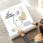 affiche avec des formes abstraites beiges et bleues une main et un visage en art au sol.webp