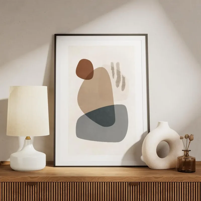 affiche avec des formes abstraites en gris bleu beige et marron sur un fond clai meuble.webp