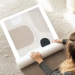 affiche avec des formes abstraites en gris clair beige et noir sur fond beige te au sol.webp