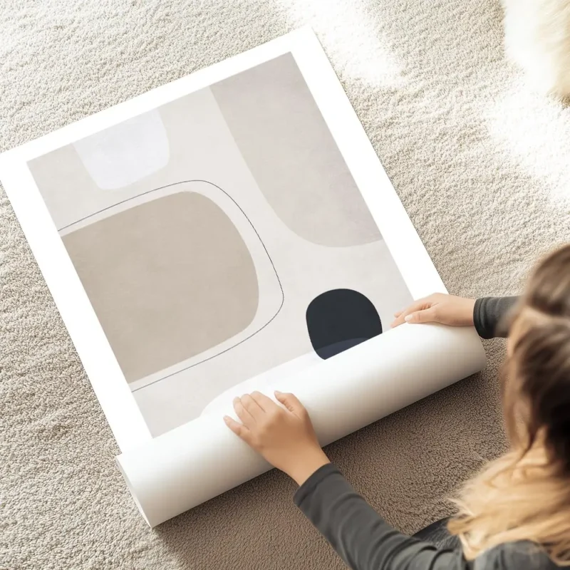 affiche avec des formes abstraites en gris clair beige et noir sur fond beige te au sol.webp