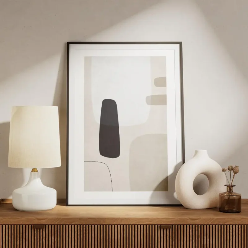 affiche avec des formes abstraites en noir gris clair et beige sur un fond beige meuble.webp