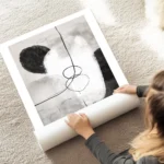affiche avec des formes abstraites monochromes en noir gris et blanc et des lign au sol.webp