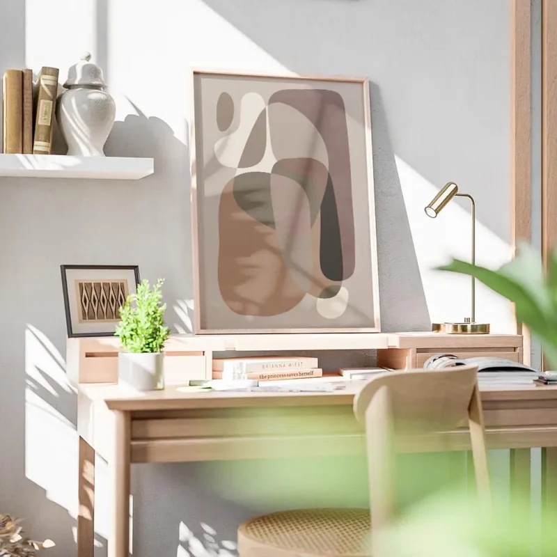 affiche avec des formes courbes et organiques de couleurs beige et marron sur un bureau.webp