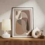 affiche avec des formes courbes et organiques de couleurs beige et marron sur un meuble.webp