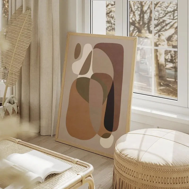 affiche avec des formes courbes et organiques de couleurs beige et marron sur un salon beige.webp