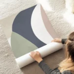 affiche avec des formes geometriques allongees aux couleurs sobres bleu vert ros au sol.webp