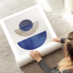 affiche avec des formes geometriques bleues et beiges sur fond gris beige typogr au sol.webp