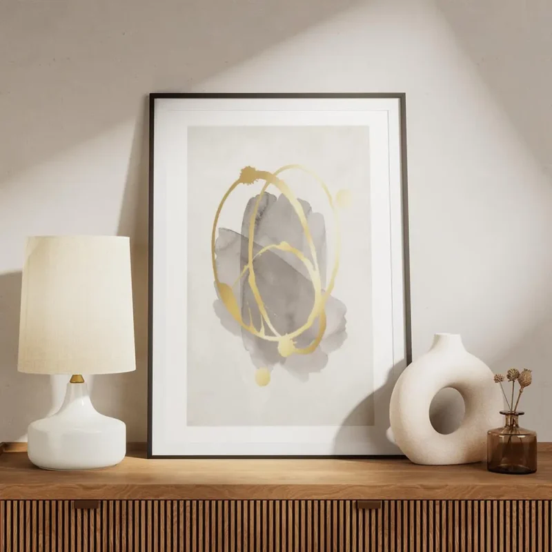 affiche avec des formes grises aquarelle et cercles dores abstraits projetes sur meuble.webp