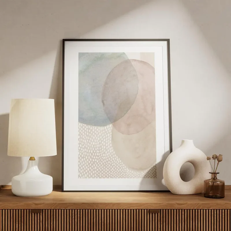 affiche avec des formes rondes en beige rose et bleu et un fond de points blancs meuble.webp