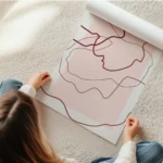 affiche avec des lignes abstraites rouges sur un fond rose clair et beige creant en rouleau.webp