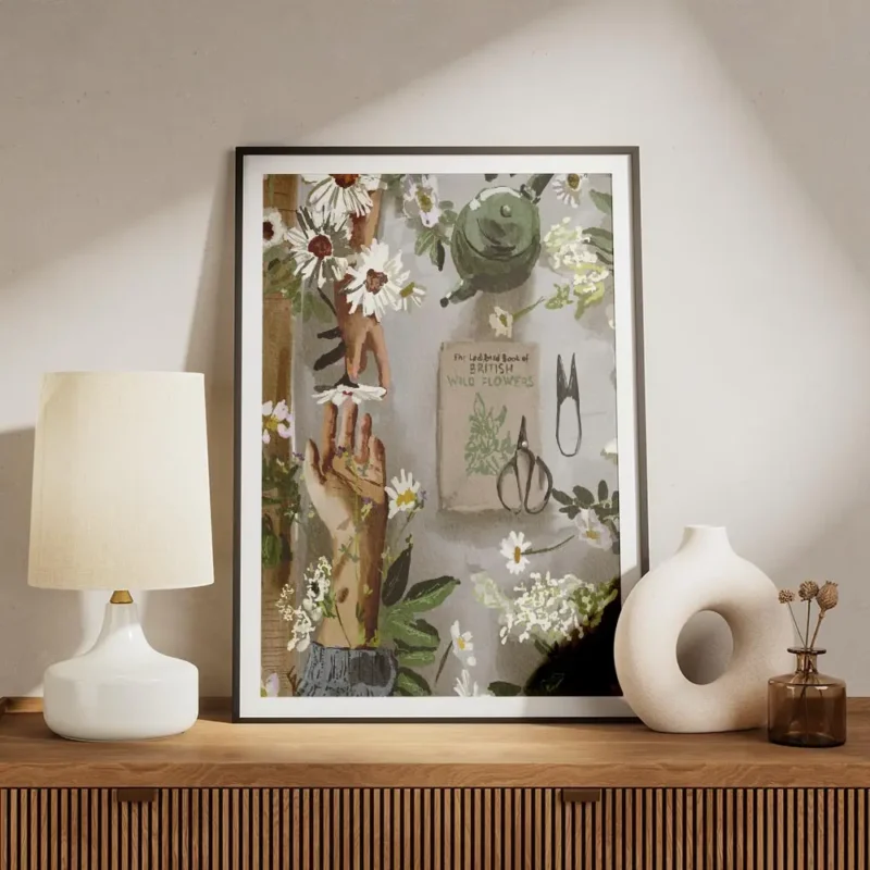 affiche avec des mains et des fleurs blanches un livre un arrosoir vert et des o meuble.webp