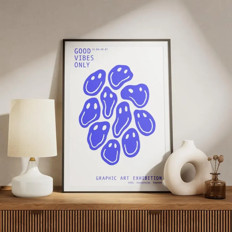 affiche avec des smileys bleus deformes et du texte bleu good vibes only sur fon meuble.webp
