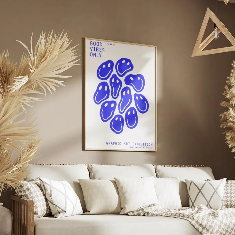 affiche avec des smileys bleus deformes et du texte bleu good vibes only sur fon salon.webp