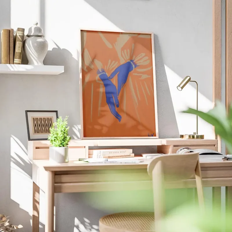affiche avec deux mains bleues aux poignets perles sur un fond orange vif entour bureau.webp