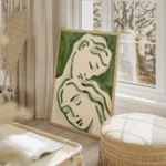 affiche avec deux visages stylises en vert fonce et clair evoquant lamour sur un salon beige.webp