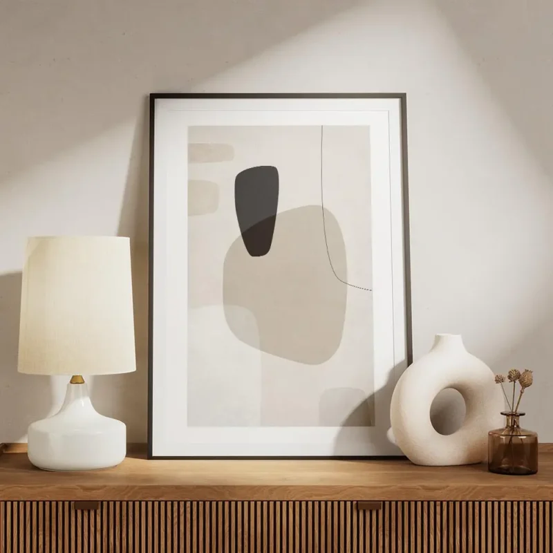 affiche avec formes abstraites en beige blanc et gris fonce sur fond texture ave meuble.webp
