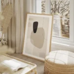 affiche avec formes abstraites en beige blanc et gris fonce sur fond texture ave salon beige.webp