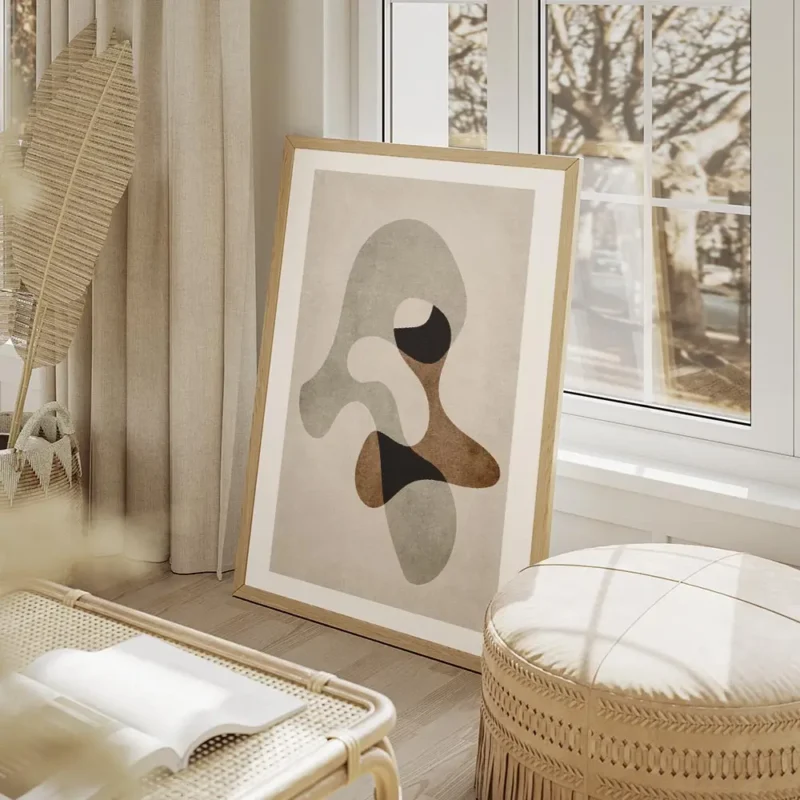 affiche avec formes abstraites grises marron et noires sur fond beige avec un ef salon beige.webp