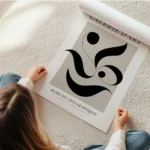 affiche avec formes abstraites noires dans un carre beige sur fond clair avec te en rouleau.webp