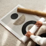 affiche avec formes abstraites noires et beiges sur fond gris beige typographie enroule.webp