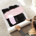 affiche avec formes abstraites noires et roses peintes a laquarelle sur fond gri au sol.webp