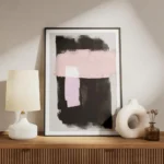 affiche avec formes abstraites noires et roses peintes a laquarelle sur fond gri meuble.webp